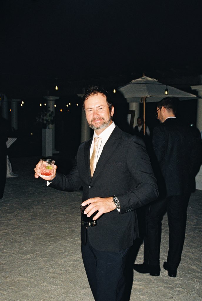 wedding guest shows off his drinks during cocktail hour