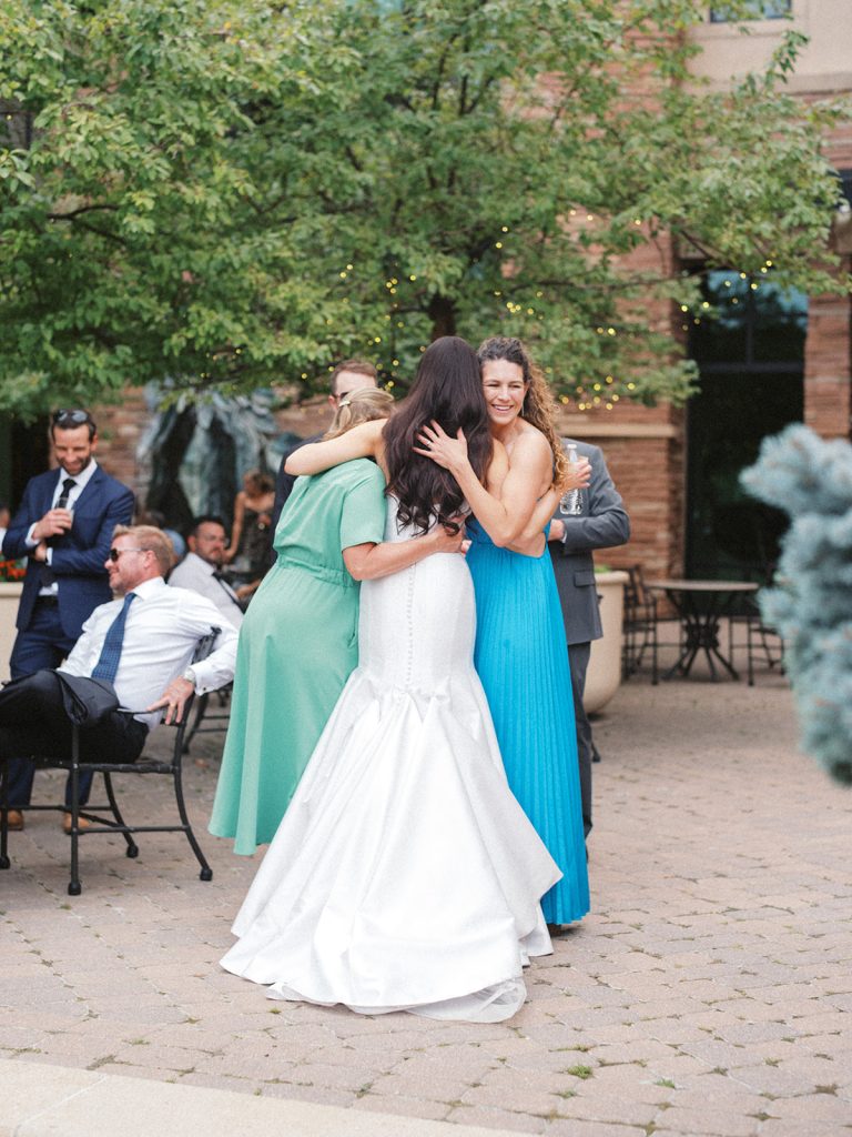 Wedding guests celebrate with the bride during a wedding at the St. Julien Boulder wedding on the terrace